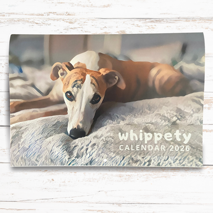 Wall calendar cover featuring a whippet dog with 'whippety calendar 2026' text on a wooden surface.