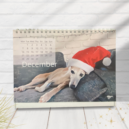 Small calendar with a whippet dog wearing a Santa hat on a couch, set against a white background.