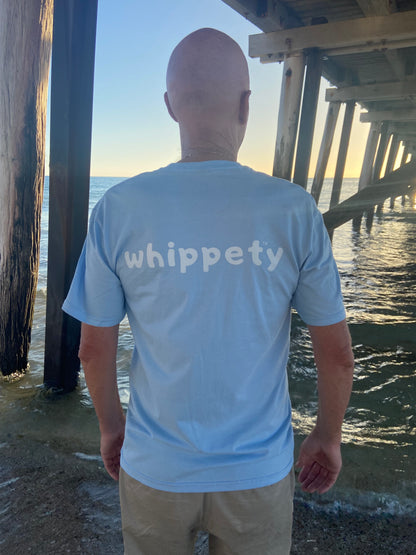 Man wearing a light blue t shirt with 'whippety' logo by sea edge