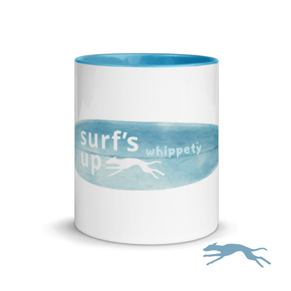 White mug front with blue rim, featuring 'surf's up whippety' text and whippet illustration on white background.